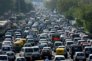 An interstate completely packed to the brim with cars and trucks; insane bumper to bumper traffic.