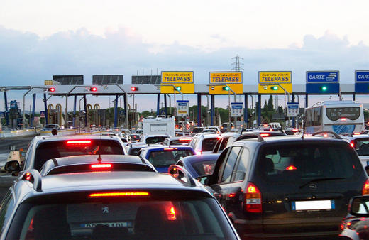 Huge line of cars waiting to pass through a toll.