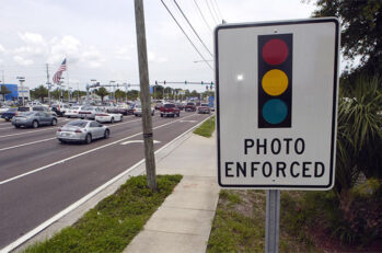 A sign with a streetlight on it that reads "Photo Enforced."