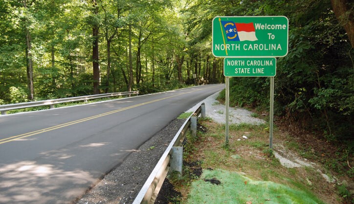 Welcome to North Carolina sign next to the highway. A common place to potentially receive a North Carolina Traffic Ticket