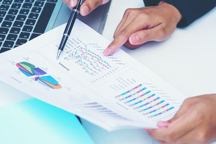 Businesswoman pointing figure numbers of total sales comparing between global regions
