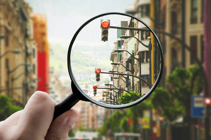 Magnifying glass focusing red lights in a city