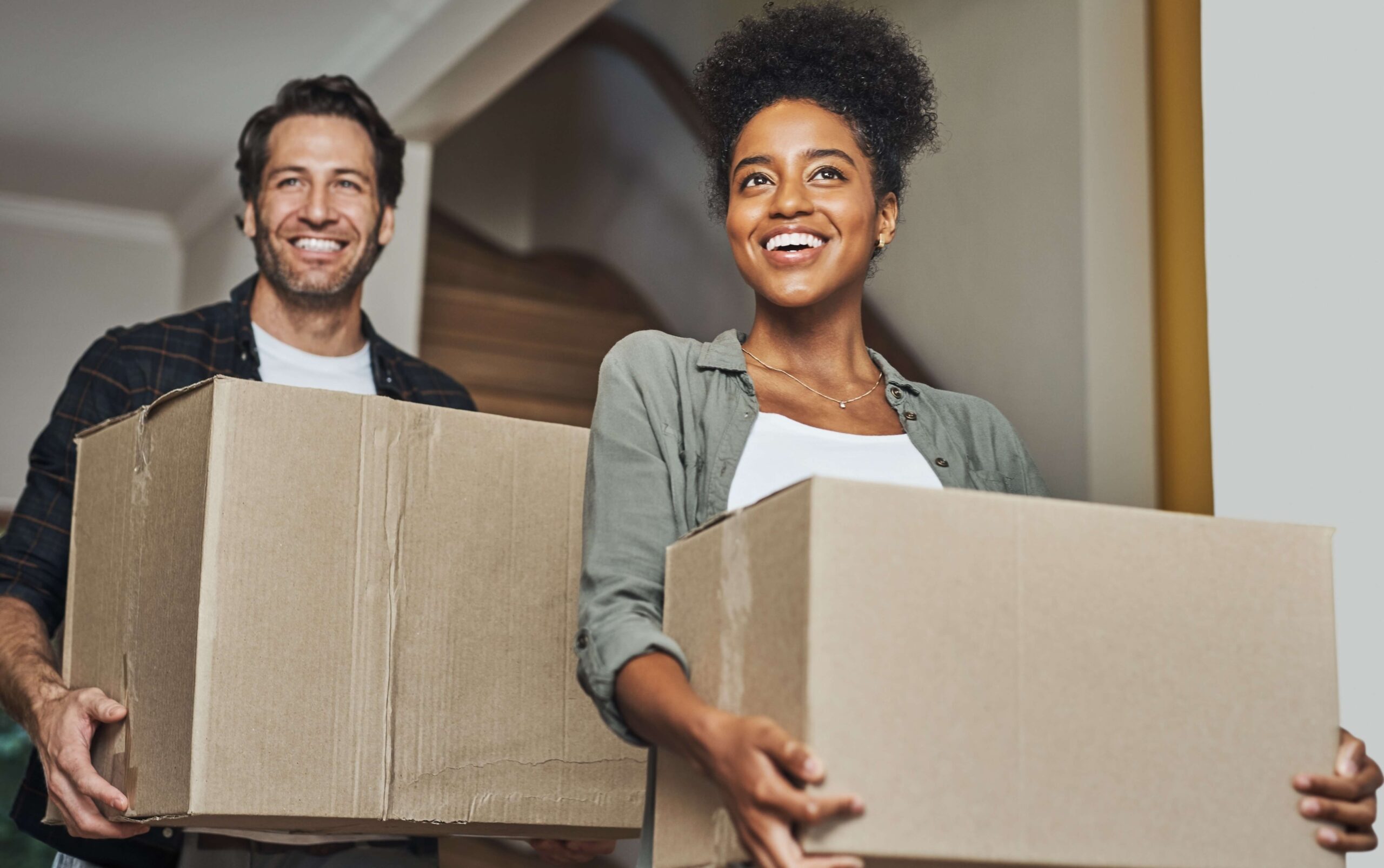 A couple walks happily through a doorway on moving day, confident in the fact that they've handled the Florida Driver's License change of address.