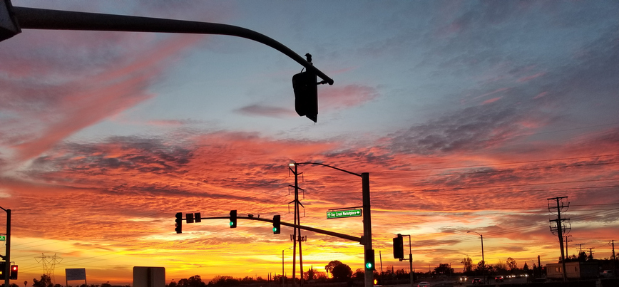 A beautiful Arizona sunset behind a red light at an intersection.